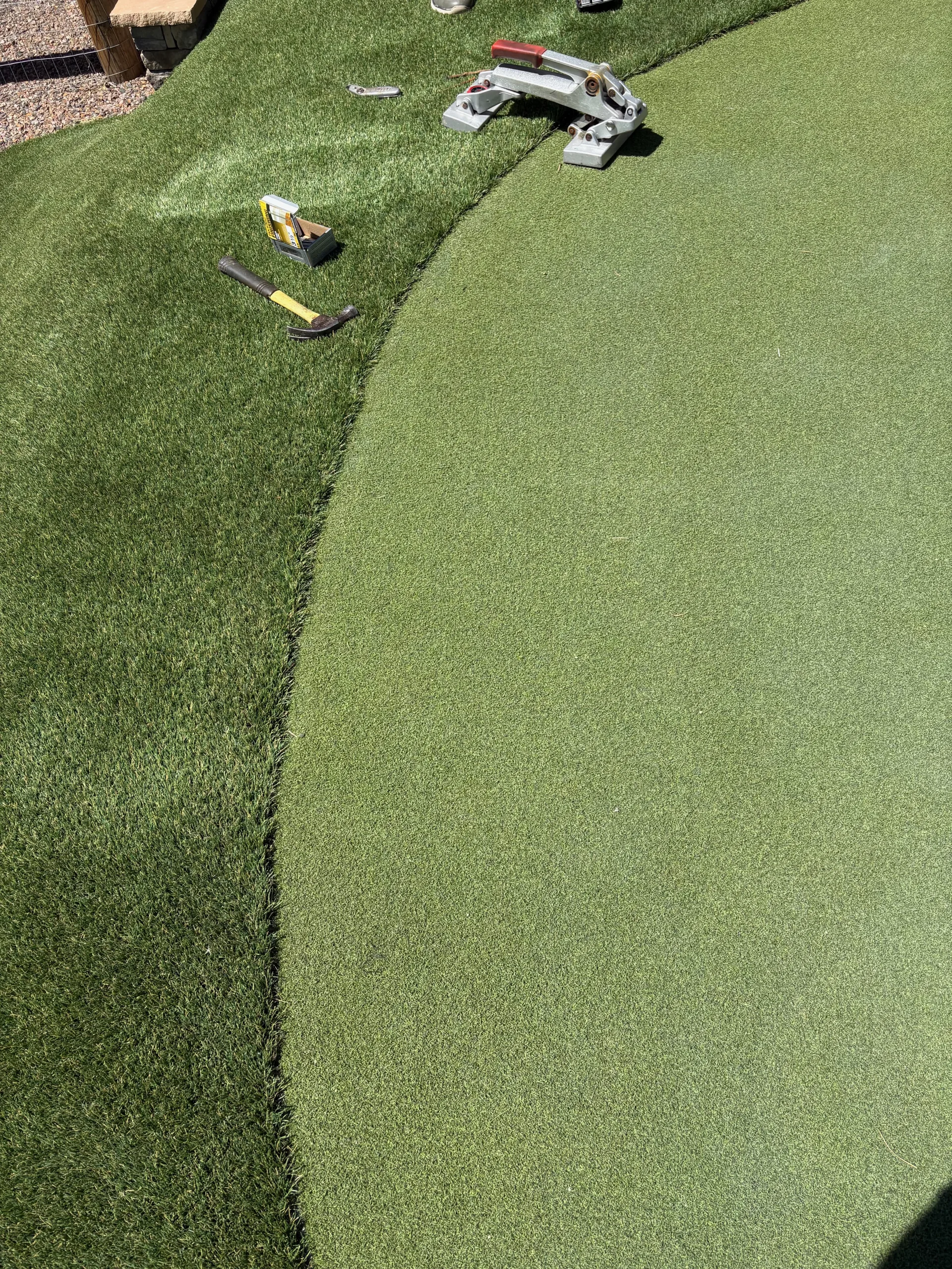 Close-up detail of a precision seam between putting surface and fringe turf